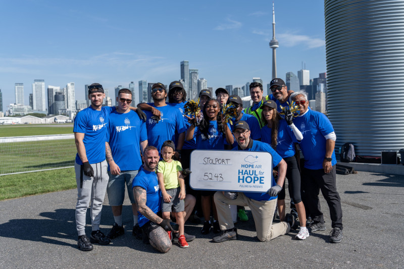 Group of people posing for a photo with the Toronto city skyline in the background.