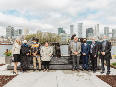 Representatives pose in front of the sculpture.