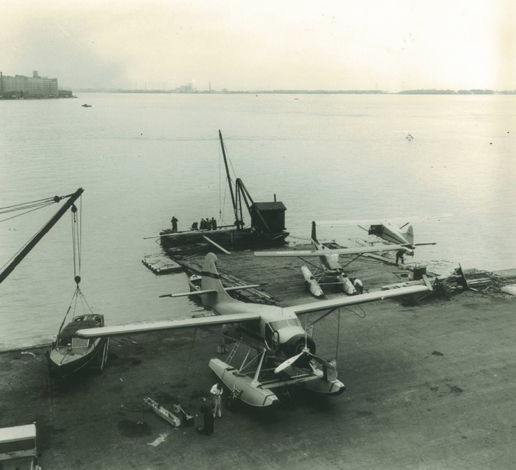 Float plane on land being looked at by mechanics