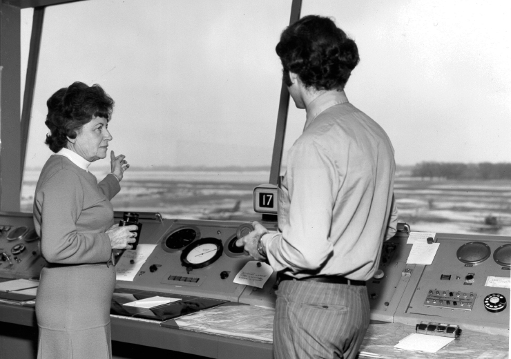 A lady and a gentleman in air traffic control looking out over the runway