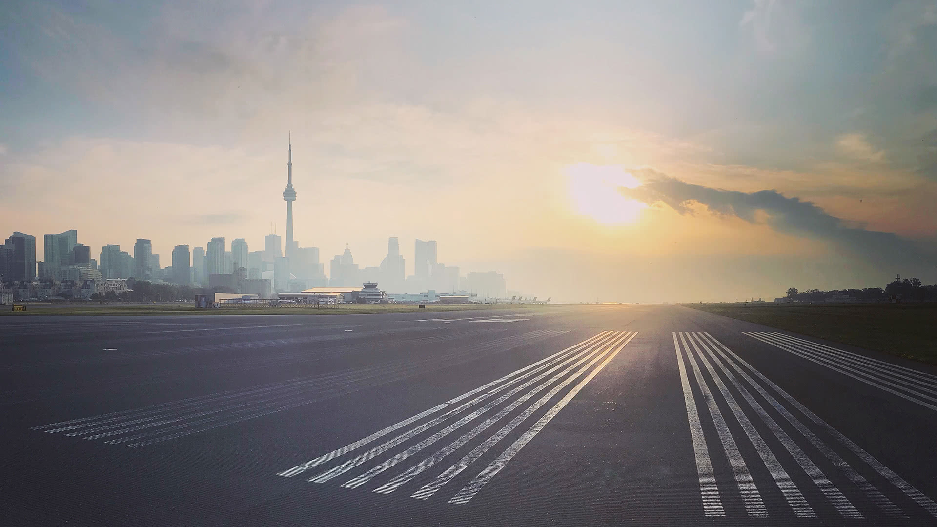 Toronto city skyline at sunrise with the airport runway in foreground