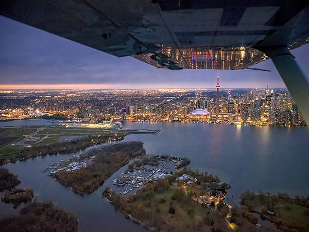 Night time aerial shot of downtown Toronto, the airport and lake Ontario