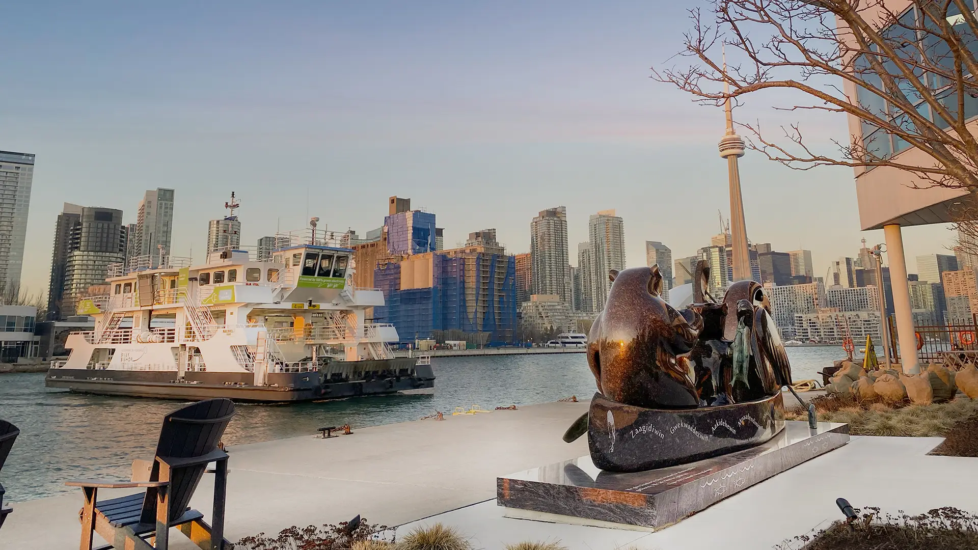Ferry and the city of Toronto in the background with a sculpture in the foreground