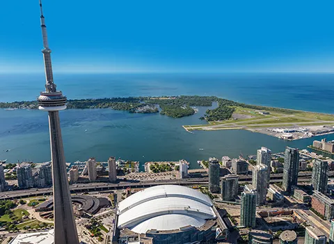 Aerial view of the CN Tower and Rogers Centre in the foreground with the island and airport in the background