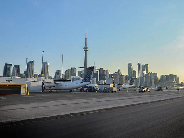 Billy Bishop Airport runway with planes and downtown Toronto in background