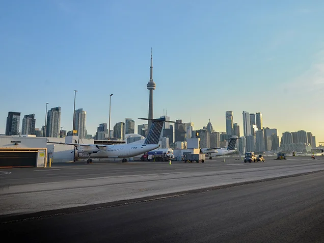 Billy Bishop Toronto City Airport runway with planes and downtown Toronto in background