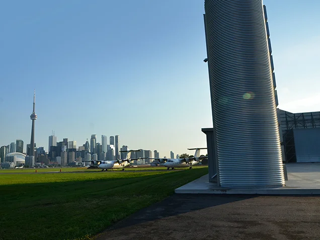 Noise barrier in foreground with the airport and the city of Toronto in the background