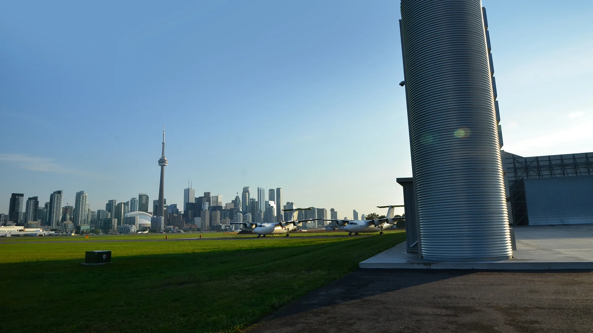 Noise barrier in foreground with the airport and the city of Toronto in the background
