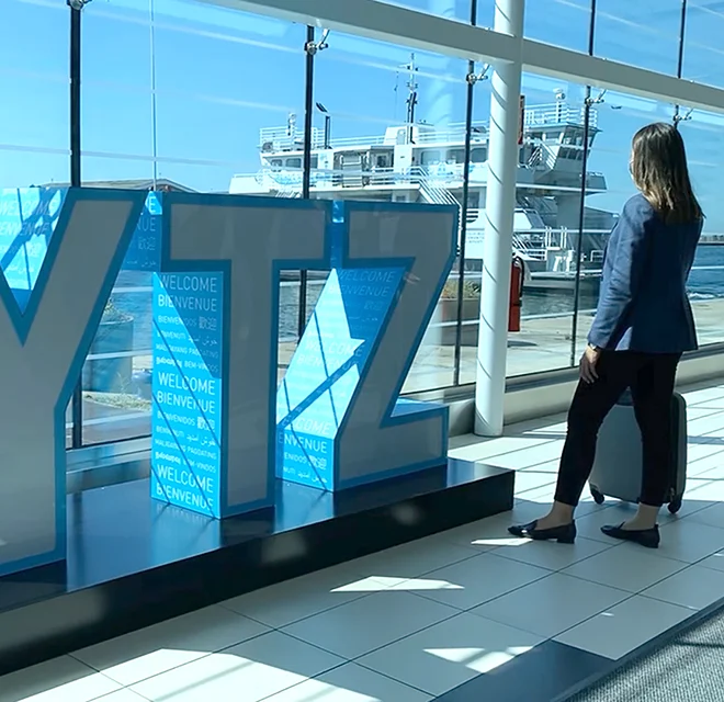 Lady standing in the airport terminal looking out the window at the ferry