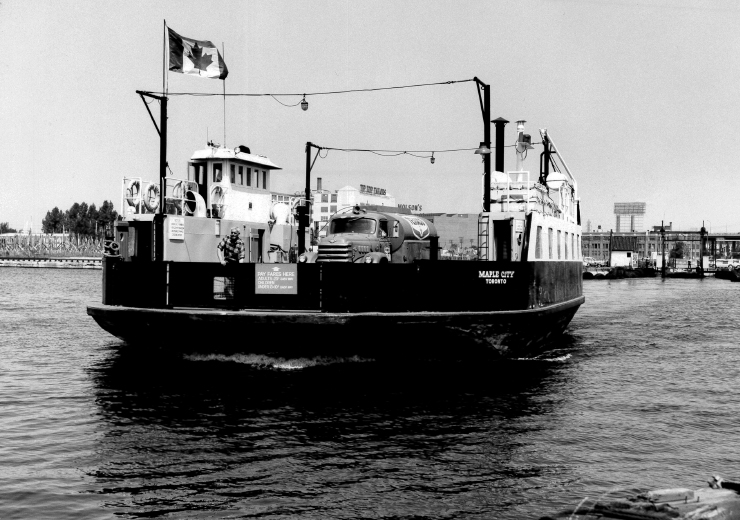 Boat with fuel truck and people on board going from mainland to airport