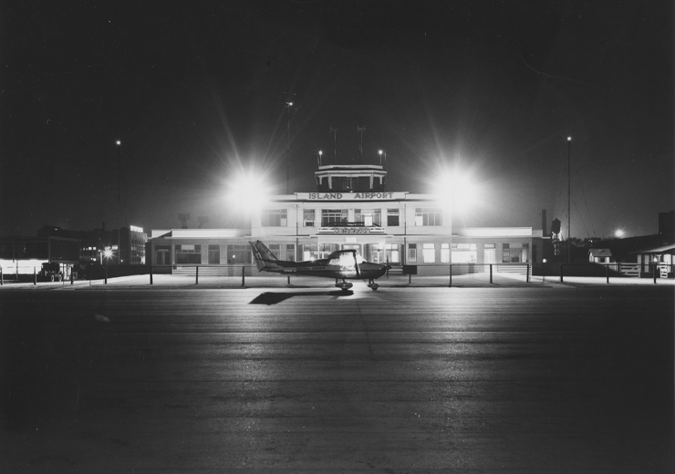 Prop plane infront of terminal at night