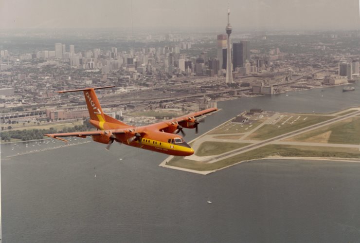 Aircraft in foreground aerial photograph with downtown Toronto and the Billy Bishop Toronto City Airport in the distance