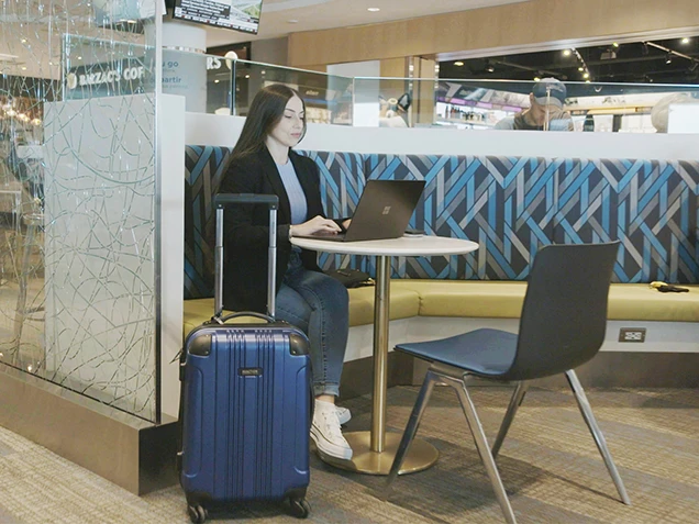 Lady working on a laptop in the airport lounge