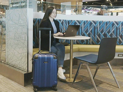 Lady working on a laptop in the airport lounge