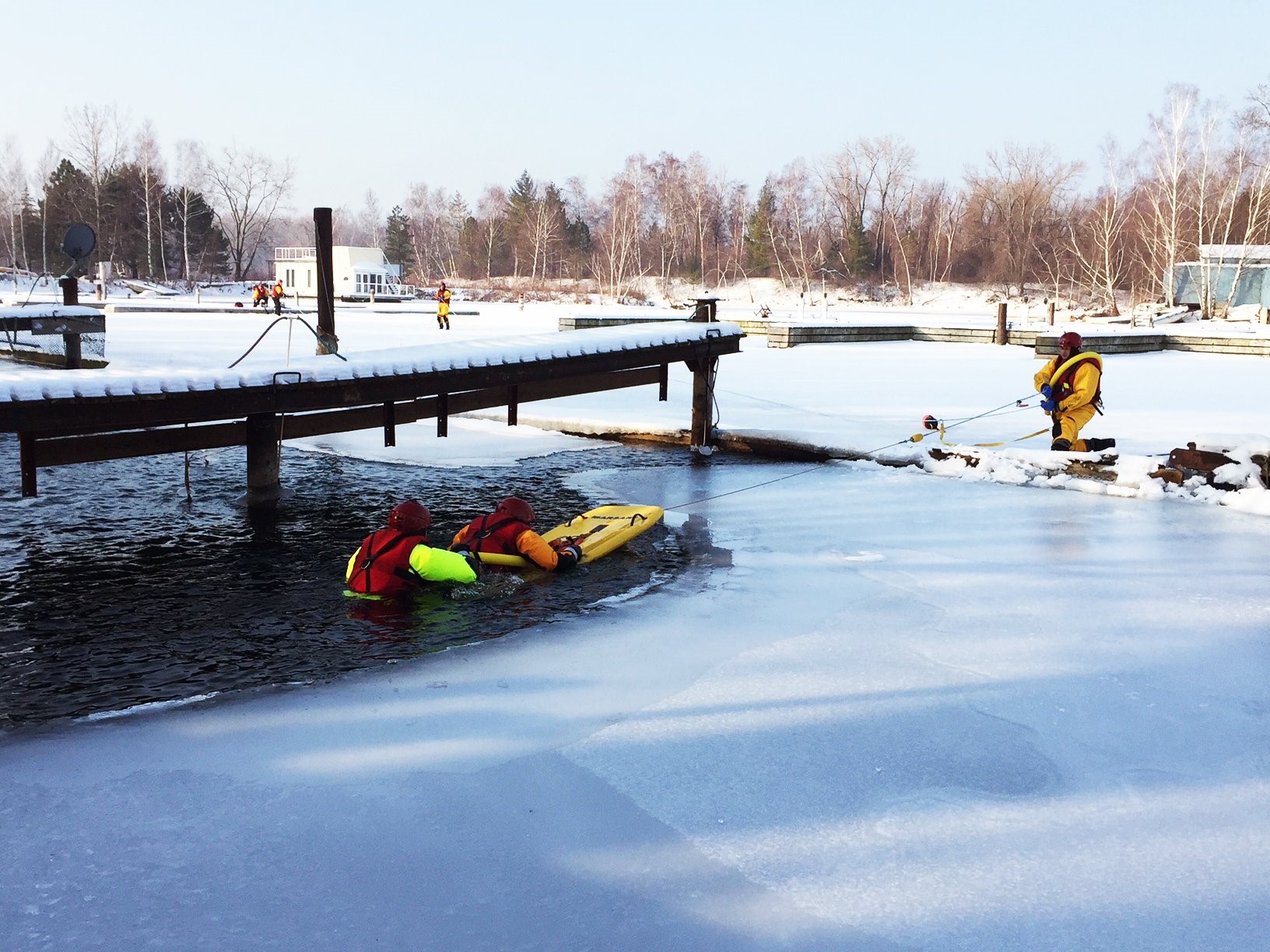 people performing an ice water rescue on a lake