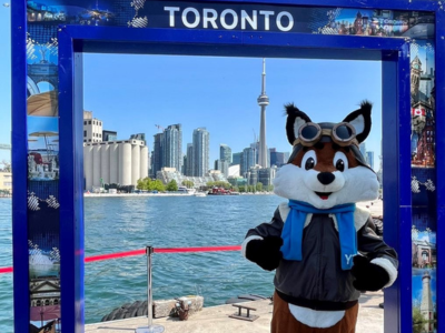 An airport mascot poses in a Toronto photo frame beside the waterfront.