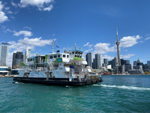 The Marilyn Bell ferry crosses the harbour with the Toronto skyline behind it.