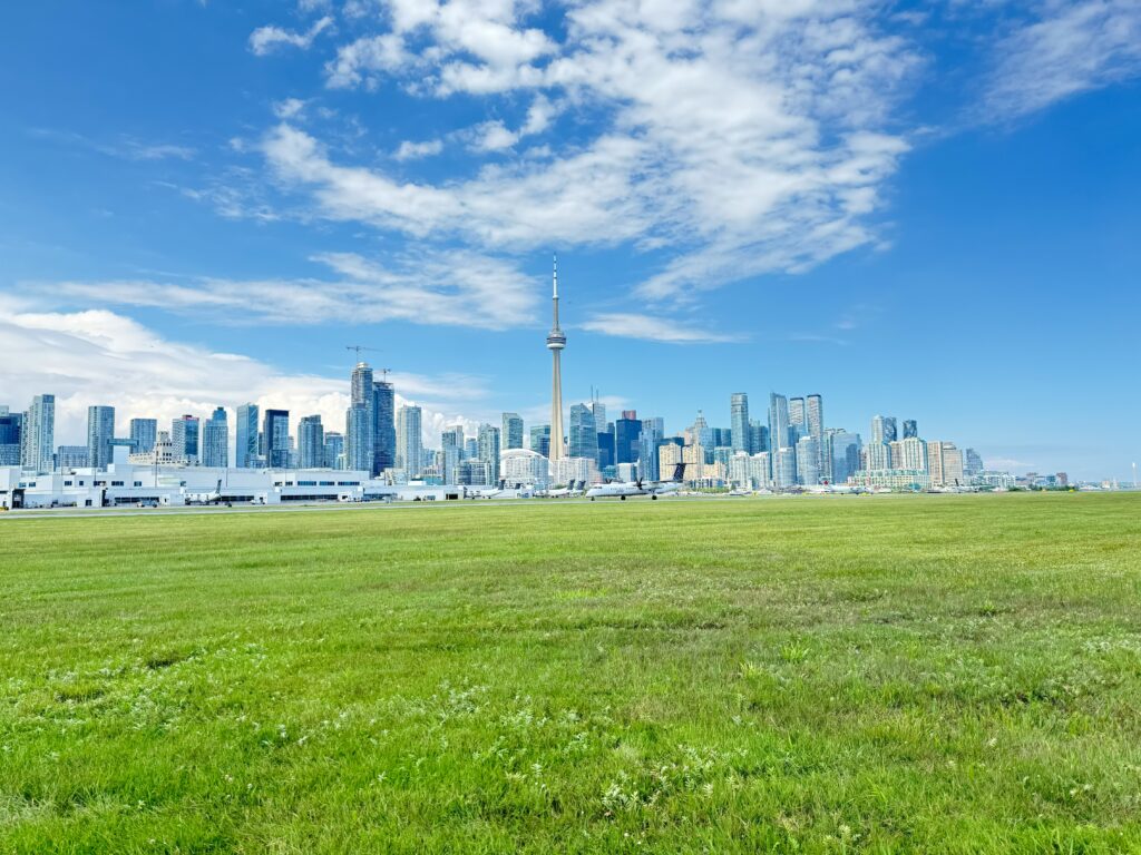 An aircraft on the airfield with the Toronto skyline beyond.