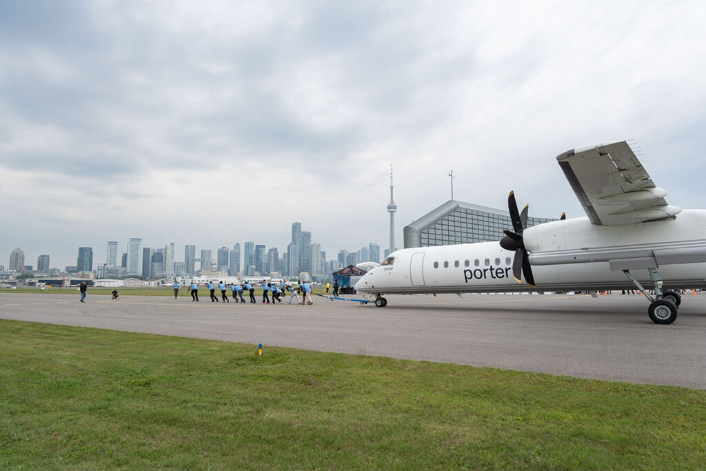 Haul for Hope participants pull an aircraft across the airport apron.