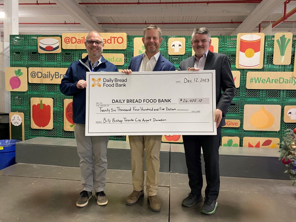 Airport representatives present a cheque at Daily Bread Food Bank.