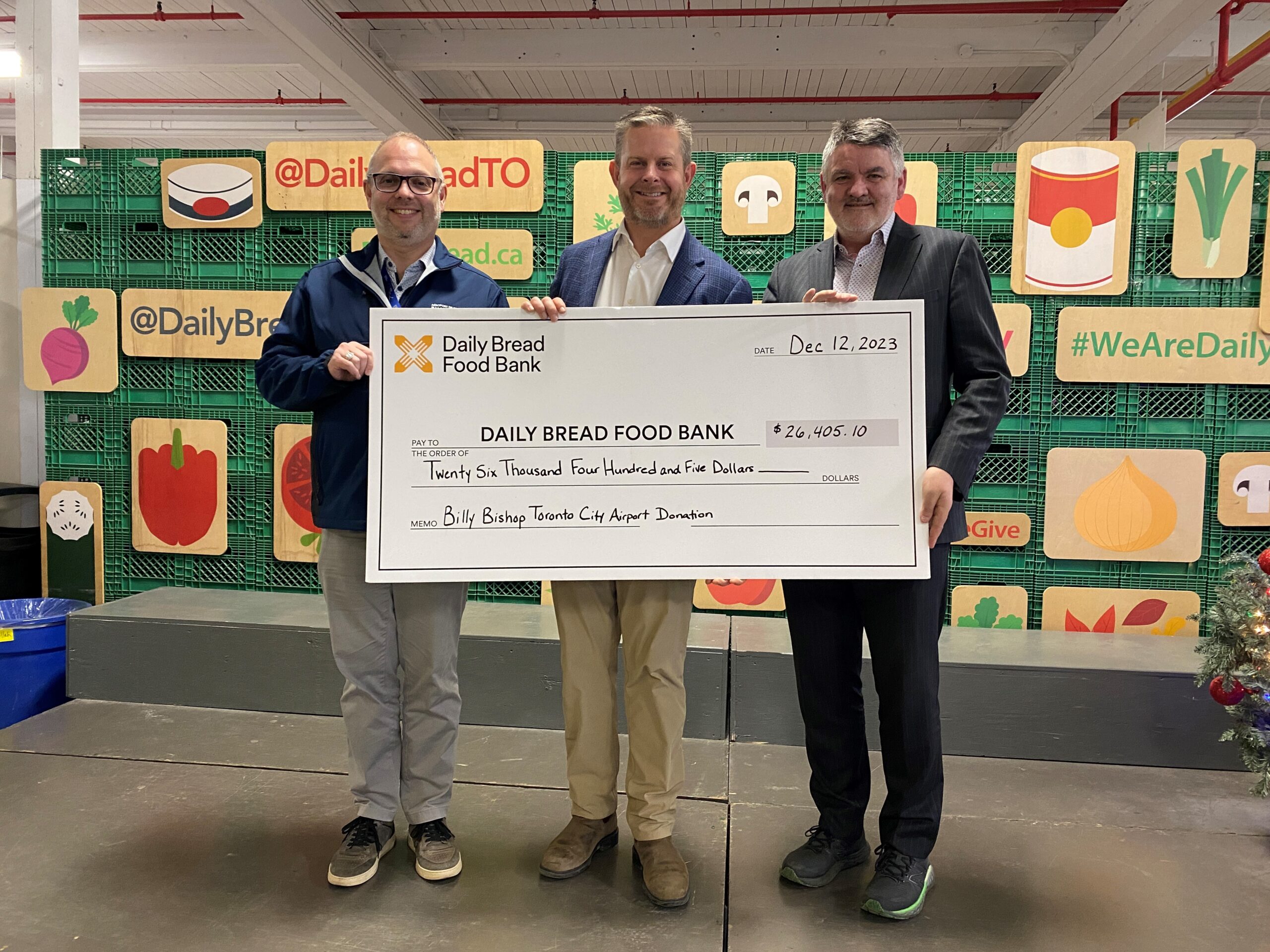Airport representatives present a cheque at Daily Bread Food Bank.