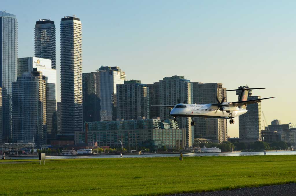Aircraft at Billy Bishop Airport with the Toronto skyline in the background.