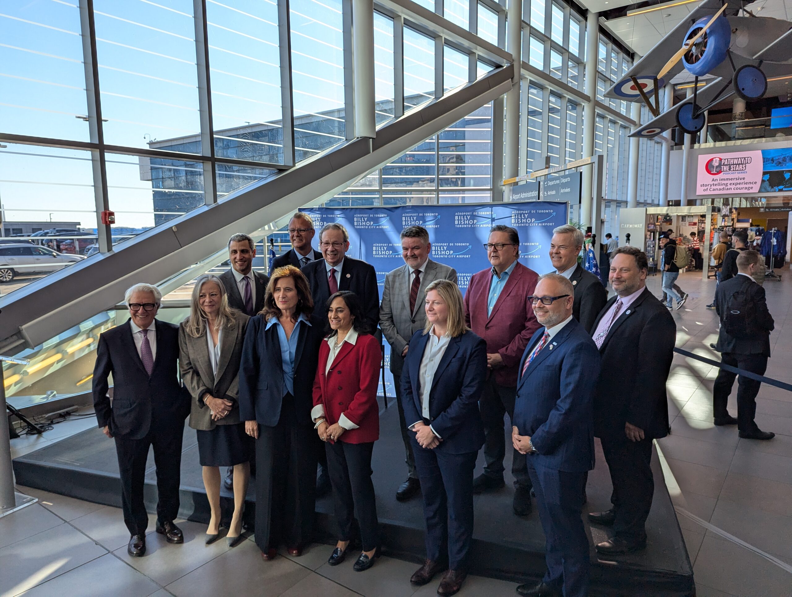 Officials gather in the airport atrium for a preclearance announcement.