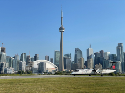 An aircraft on the airfield with the Toronto skyline beyond.