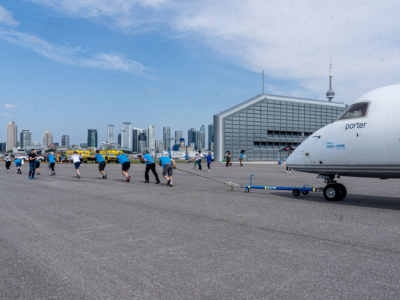 Haul for Hope participants pull an aircraft across the airport apron.