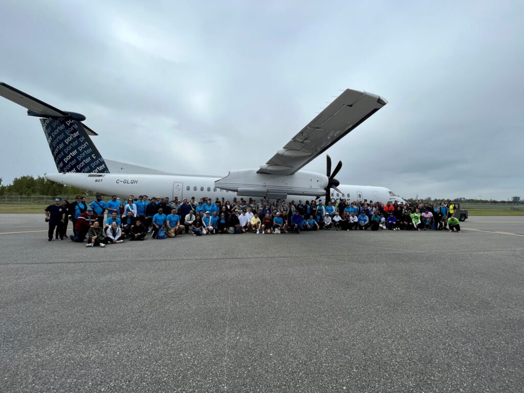 Haul for Hope participants gather beside a Porter aircraft.