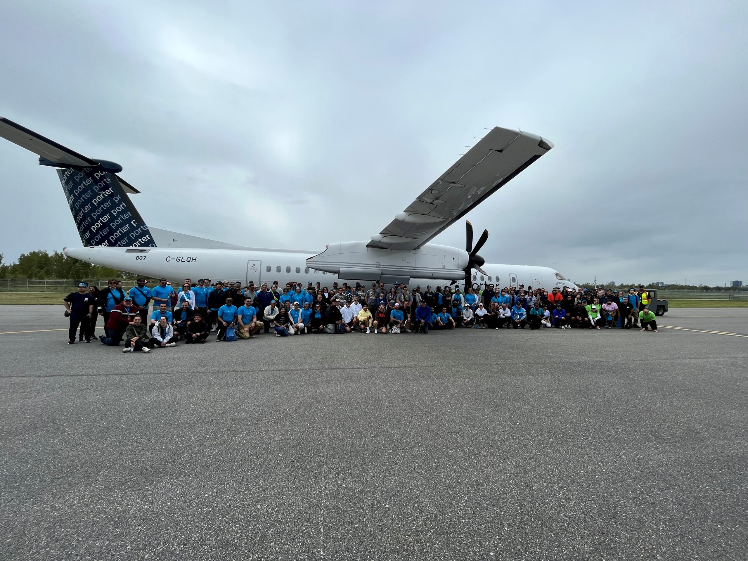Haul for Hope participants gather beside a Porter aircraft.