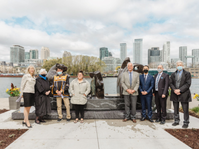 Participants gather beside the Maanjidowin sculpture at its unveiling.