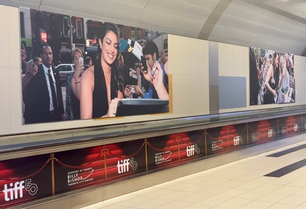 TIFF exhibition photographs displayed in the airport pedestrian tunnel.