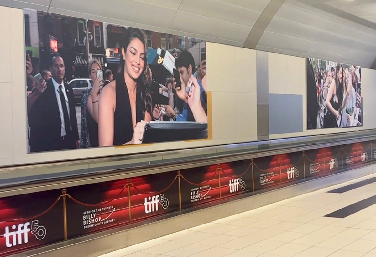 TIFF exhibition photographs displayed in the airport pedestrian tunnel.