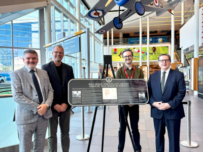 Representatives unveil a Heritage Toronto plaque marking 85 years of flight.