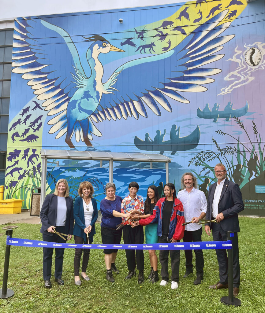 Ribbon cutting in front of the Jakarundi mural at Billy Bishop Airport.