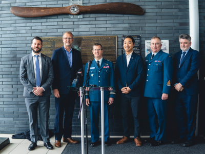 Representatives beside the Royal Canadian Air Force commemorative display at the airport.